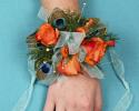 This prom corsage is great with the orange flowers and accents of peacock feathers and blue ribbon.