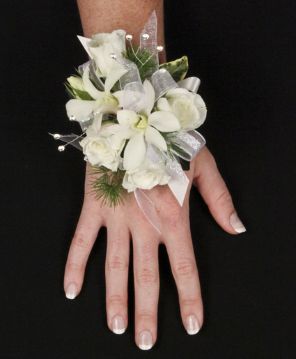 This beautiful white corsage is great for a wedding or prom. It features elegant white flowers with great details of pearls and greenery.