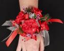 This red prom corsage features beautiful red flowers with red and white ribbon.