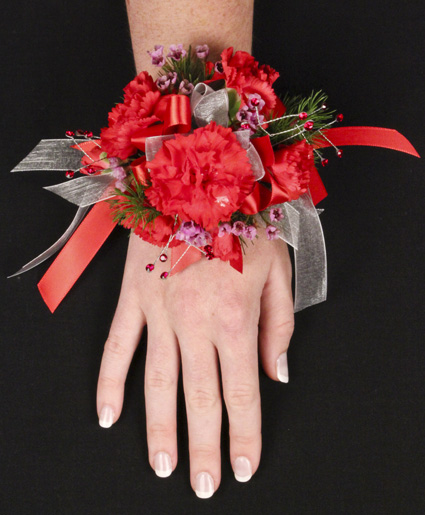 This red prom corsage features beautiful red flowers with red and white ribbon.