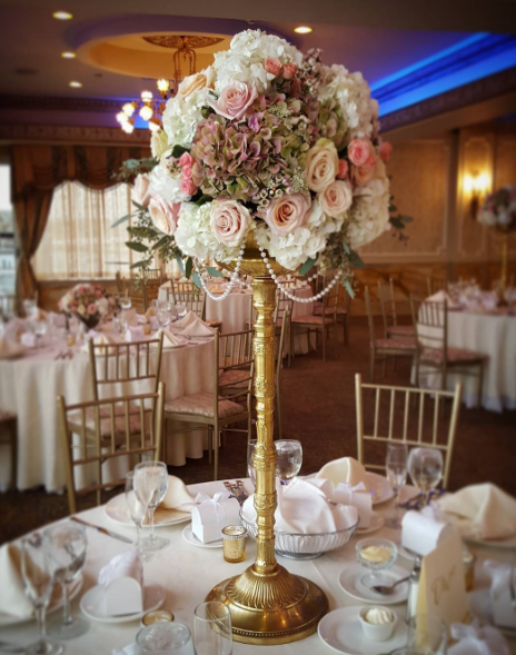 Gold is one the latest wedding trends. Give your wedding reception a classy look with fresh roses and gold details with the help of Lindenhurst Village Florist. 